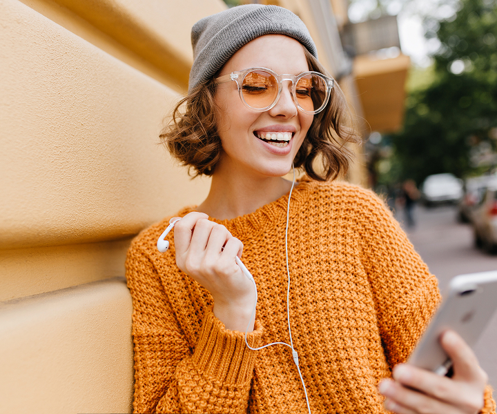 Smiling woman in headphones listening to an online course